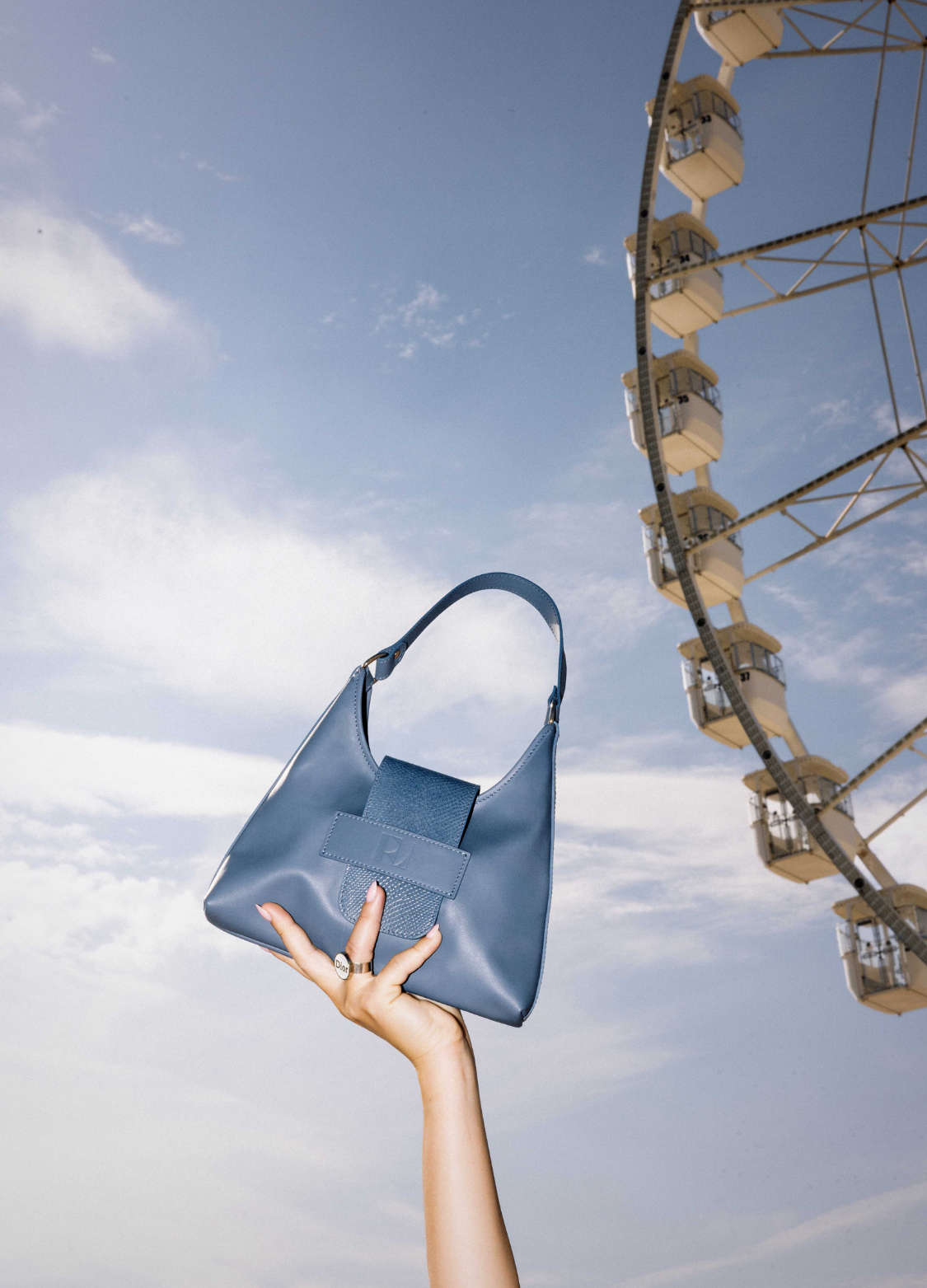 main portant le sac fada bleu grisaille taille s-en fond le ciel bleu-ERVEE