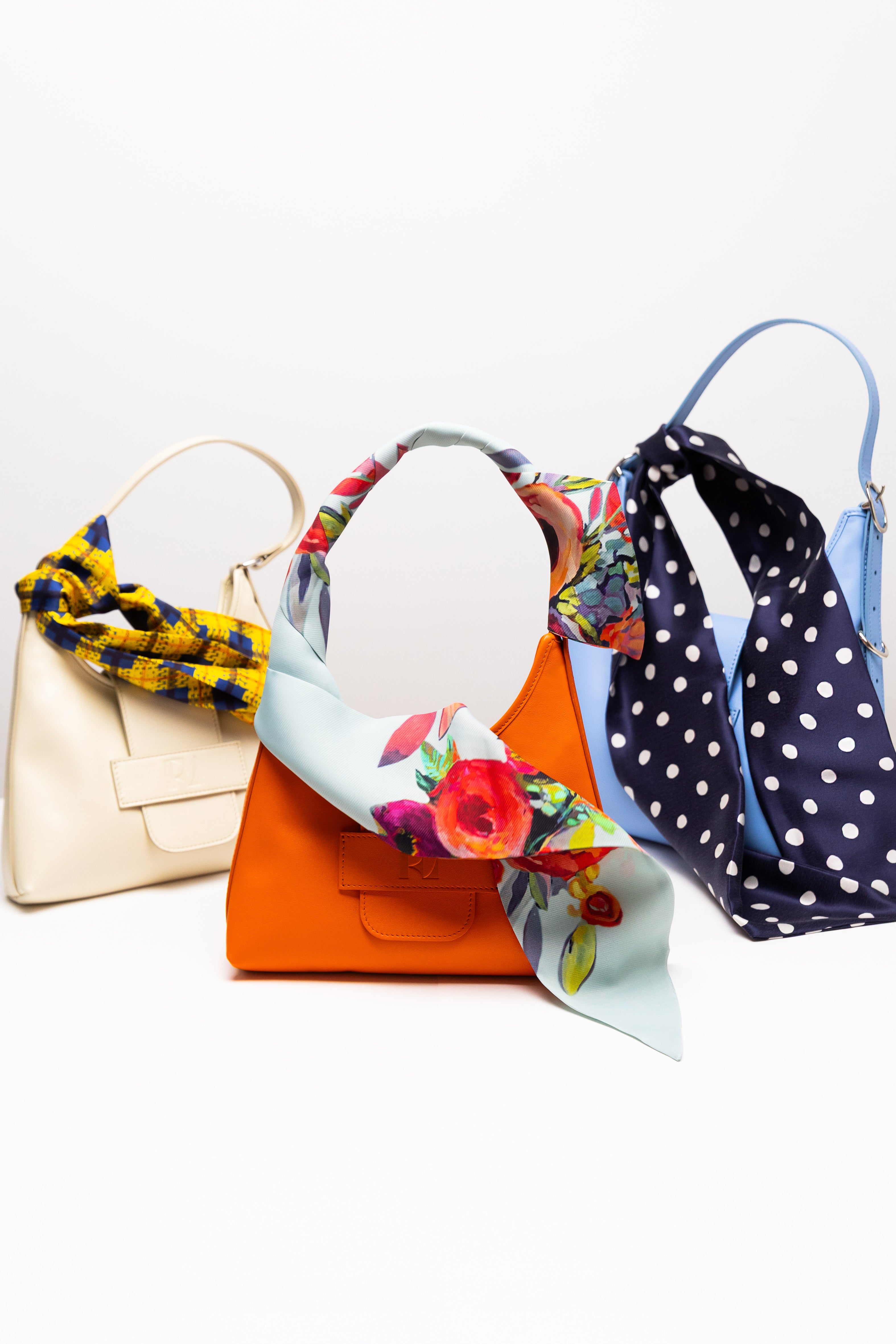 3 foulards Mistral noués autour des anses de sacs hobo