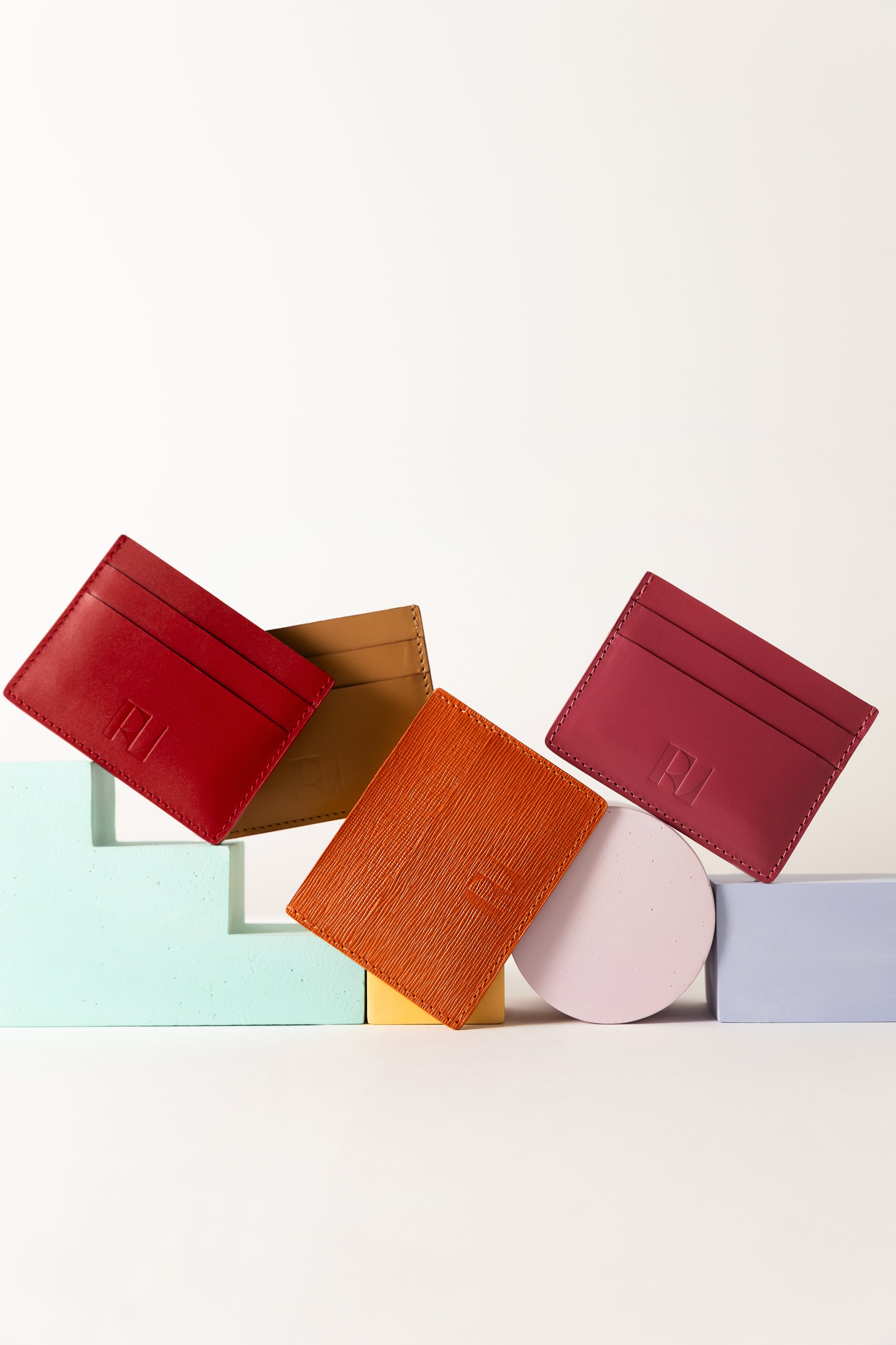 4 porte cartes mis en scène sur une table, posés sur des objets