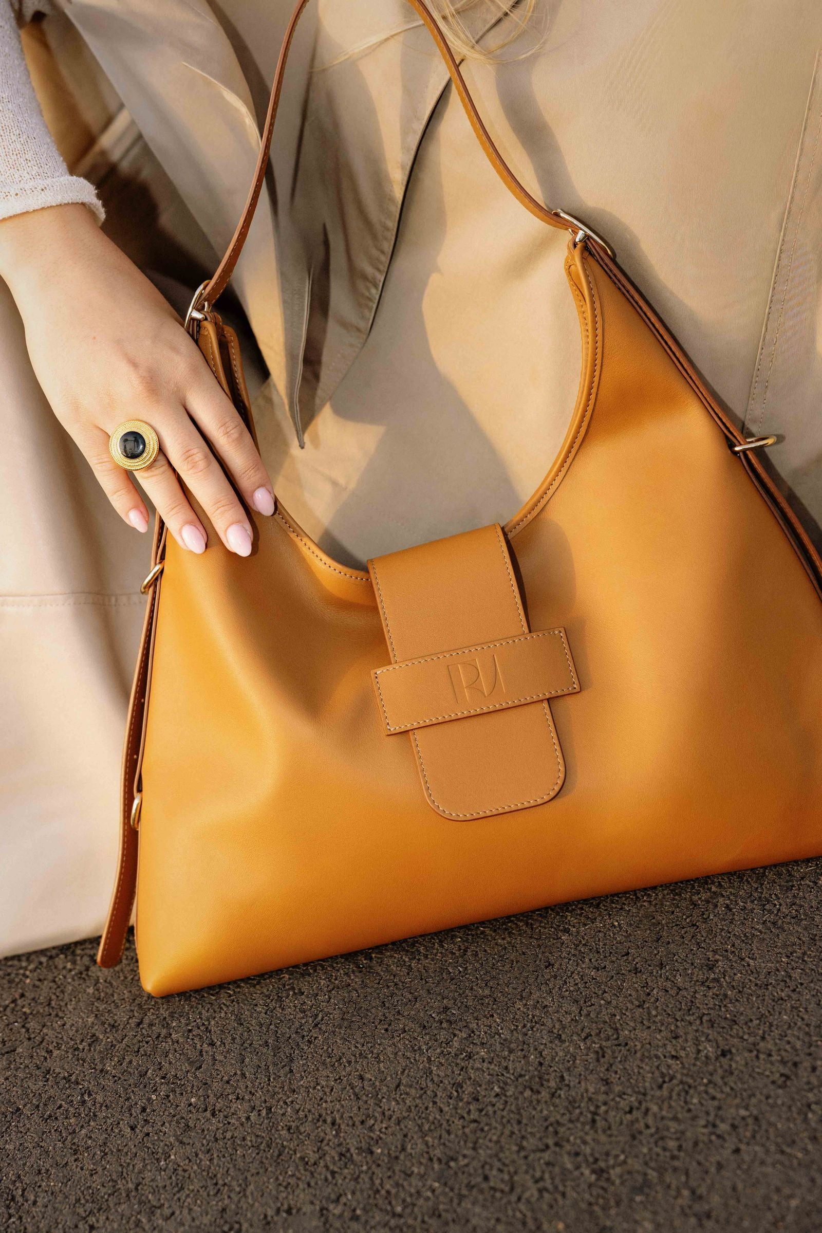 Zoom sur les mains qui portent le sac Fada taille L Camel