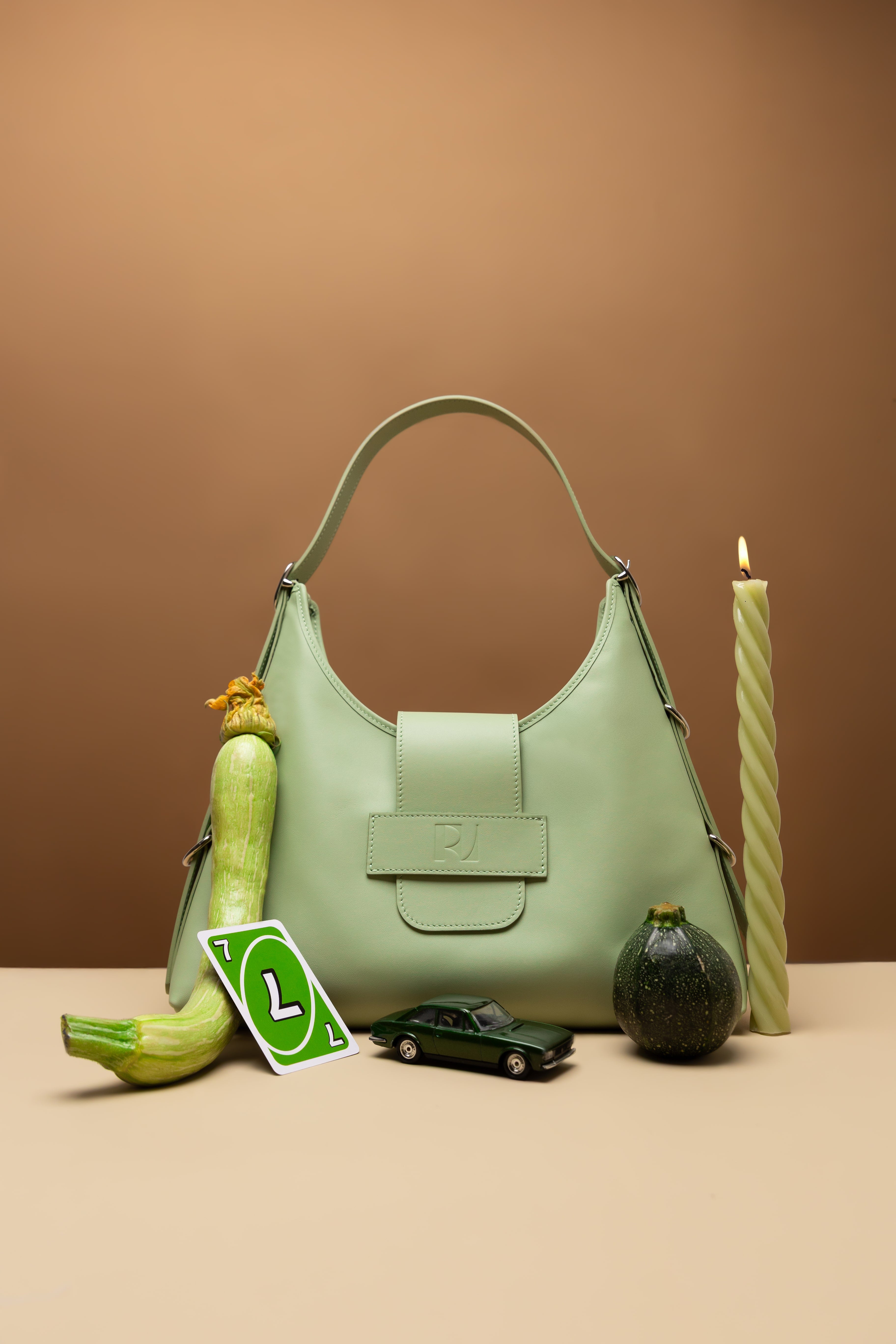 sac fada taille M vert clair mis en scène avec une bougie, courgette, carte de UNO verts